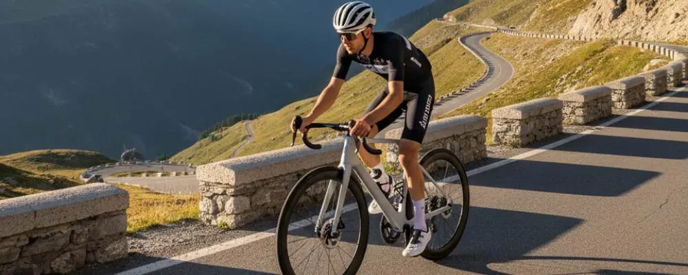 Cycliste en montée sur un vélo de route dans un col de montagne, sur une route sinueuse